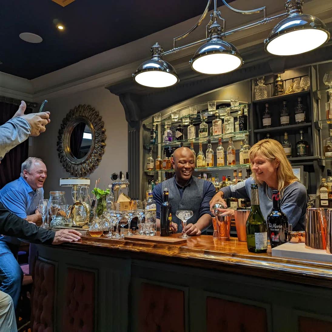 A group of people enjoy a cocktail making class in a bar in Kinsale Cork.