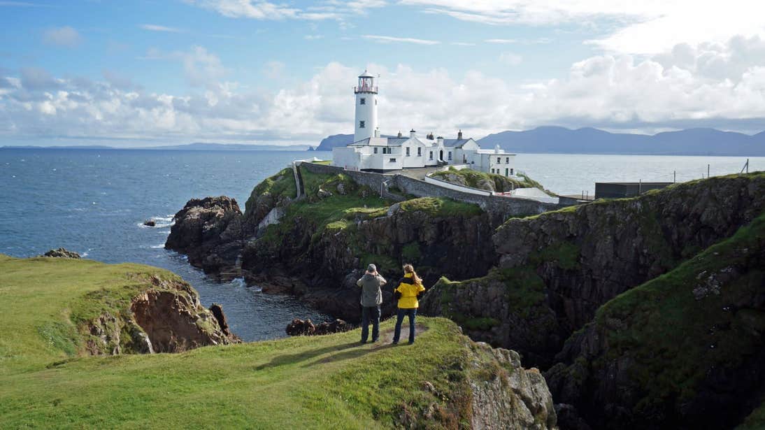 Two people taking photos of Fanad Head Lighthouse