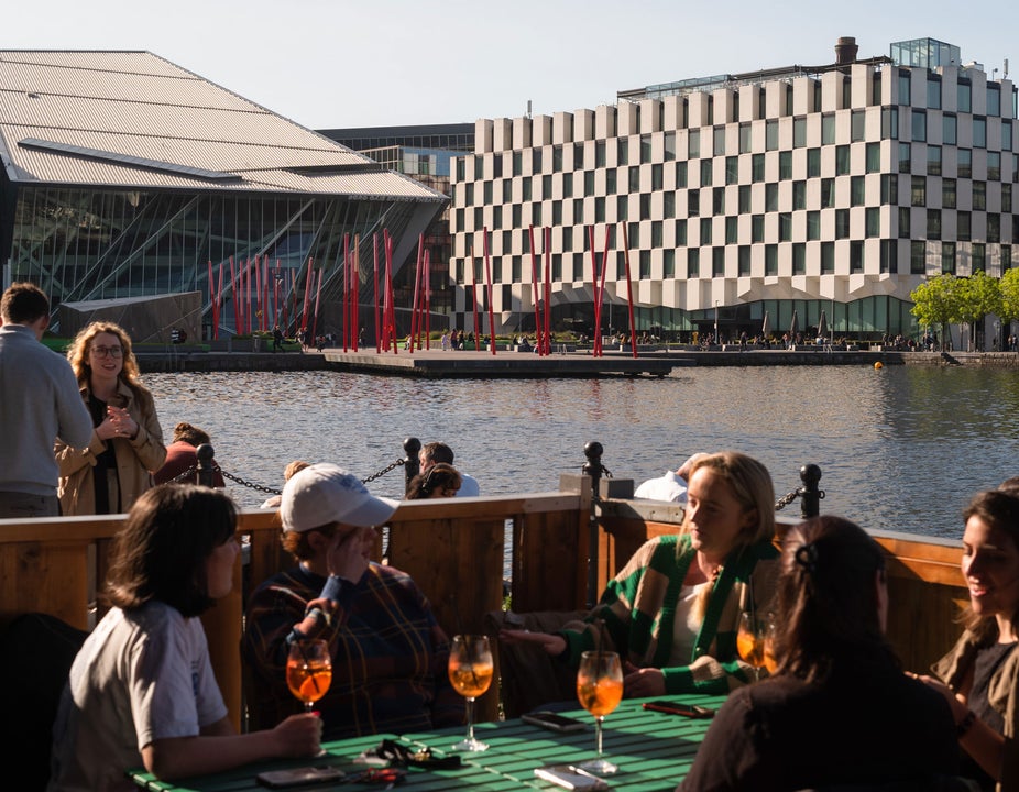 A group of people enjoying drinks in the outside seating area of Charlotte Quay Restaurant