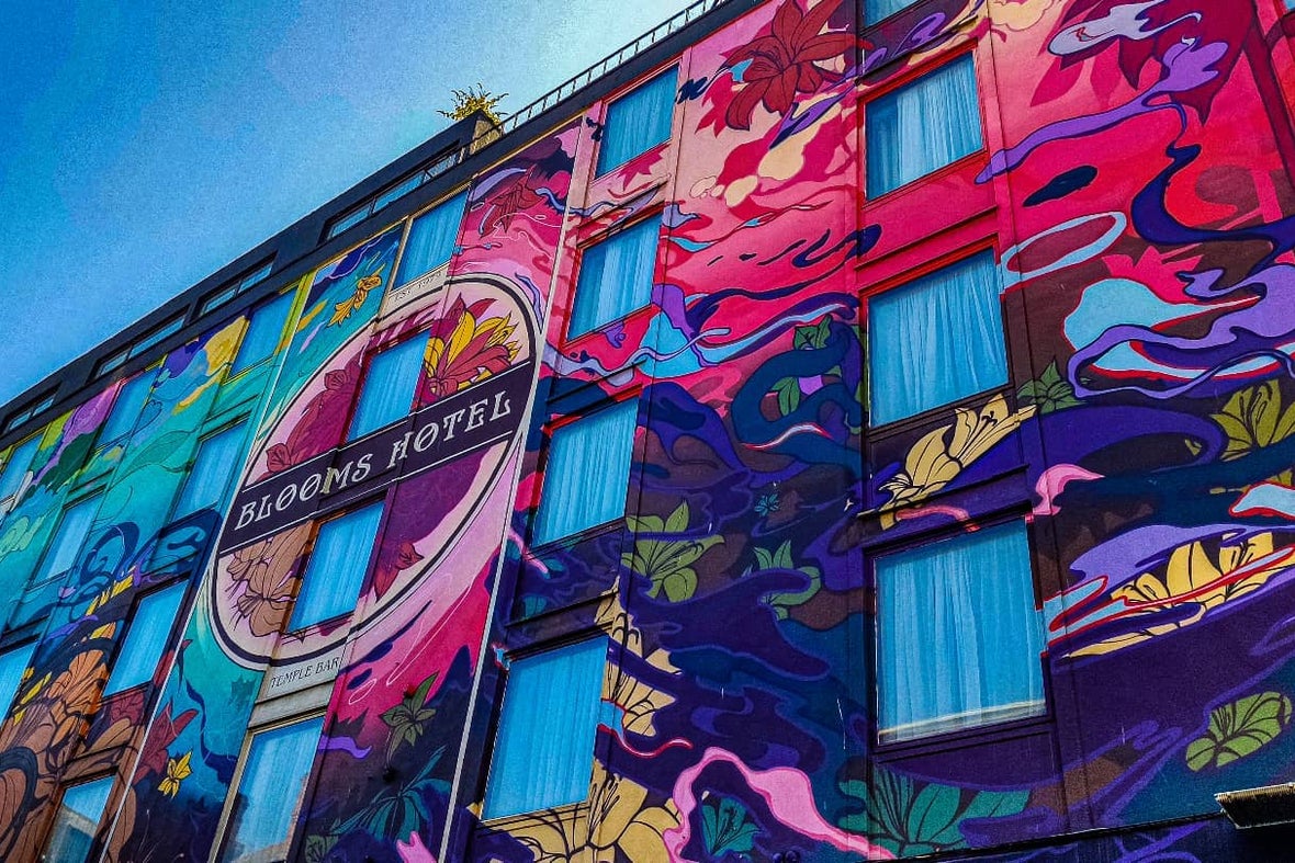A shot of the exterior of the Blooms Hotel with a mural over the side of their building.