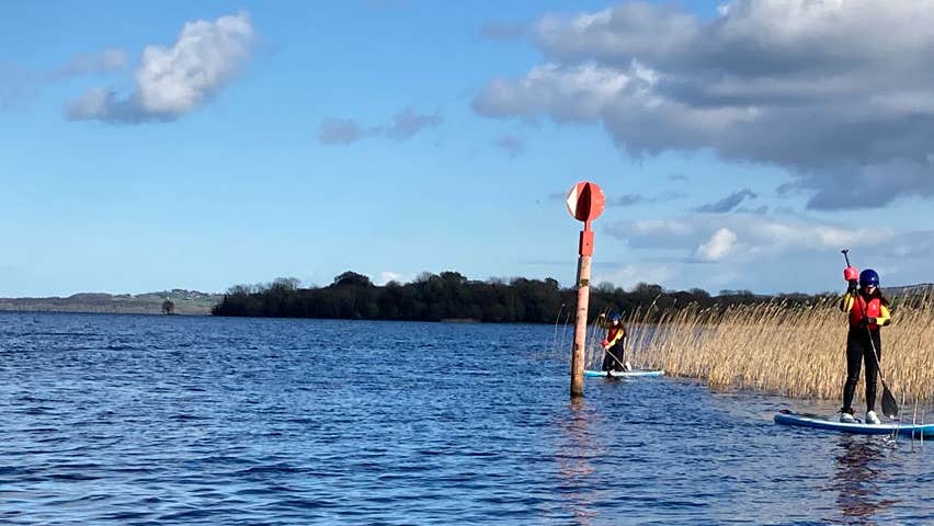 Two people out on the water enjoying stand-up paddle boarding