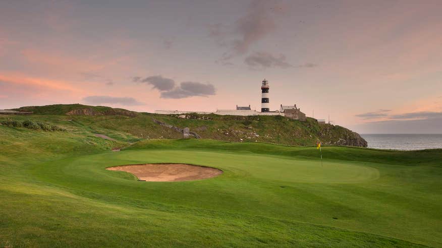 A golfer after putting with Kinsale lighthouse in the distance.