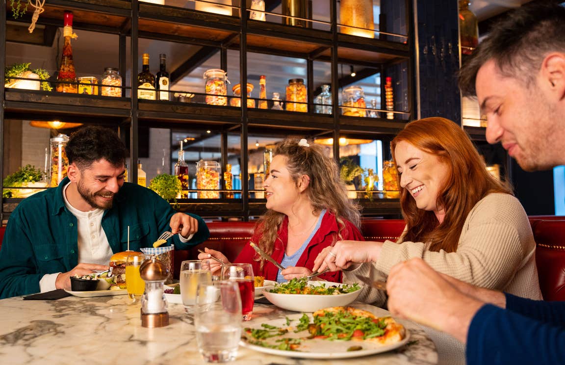 Four people enjoying a meal.