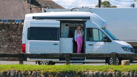 Girls standing at the side door of a Cookies Camper