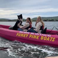 Two people in a boat with a dog