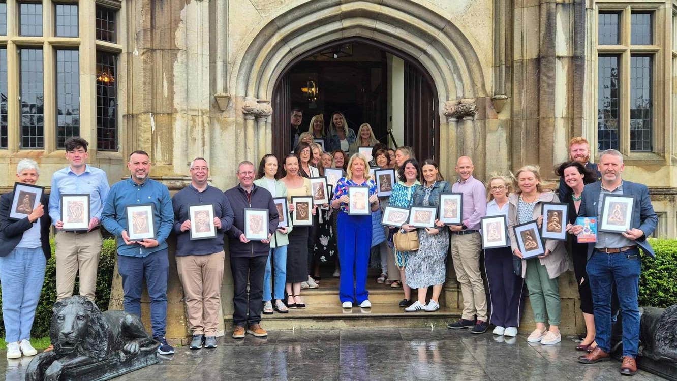 Group of people standing outside a building holding frames