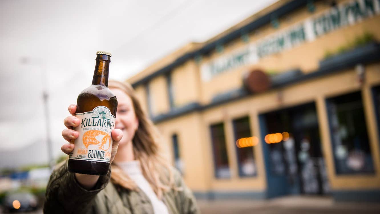 Person posing with a bottle of beer