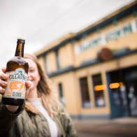 Person posing with a bottle of beer