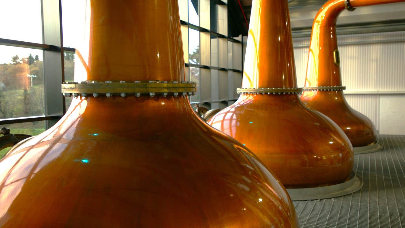 Three copper pot stills on display at The Ardara Distillery