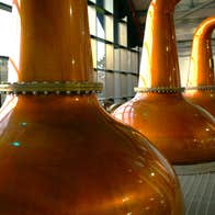 Three copper pot stills on display at The Ardara Distillery