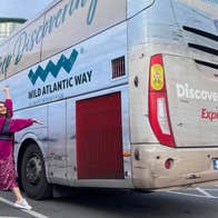 Girl standing in front of a Wild Atlantic Way Expressway bus.