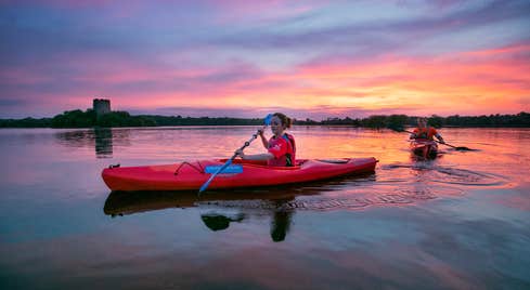 Two people kayaking on Lough Oughter in County Cavan and watching the sunset