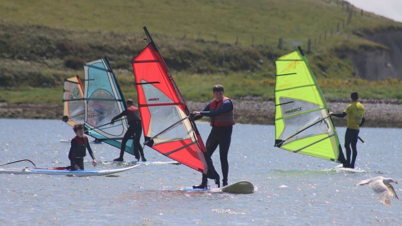 Four people windsurfing