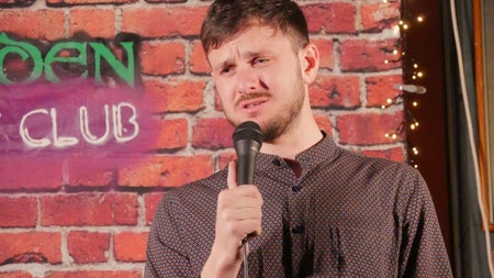 A comedian with a microphone in his hand
