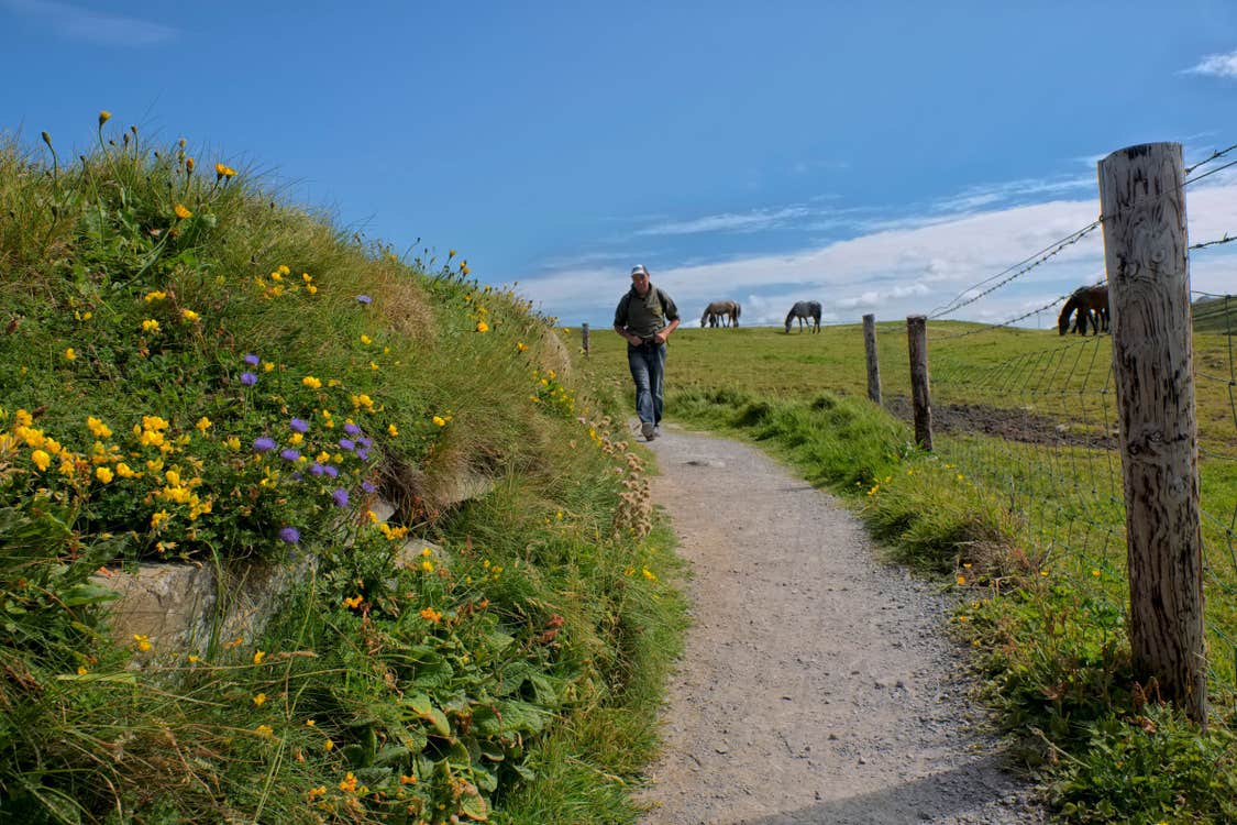 Image of a man walking along the Doolin Cliff Walk in County Clare