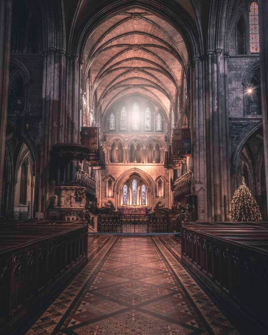 Interior facade of St Patrick's Cathedral at Christmas time with a Christmas tree off to the right of the altar.