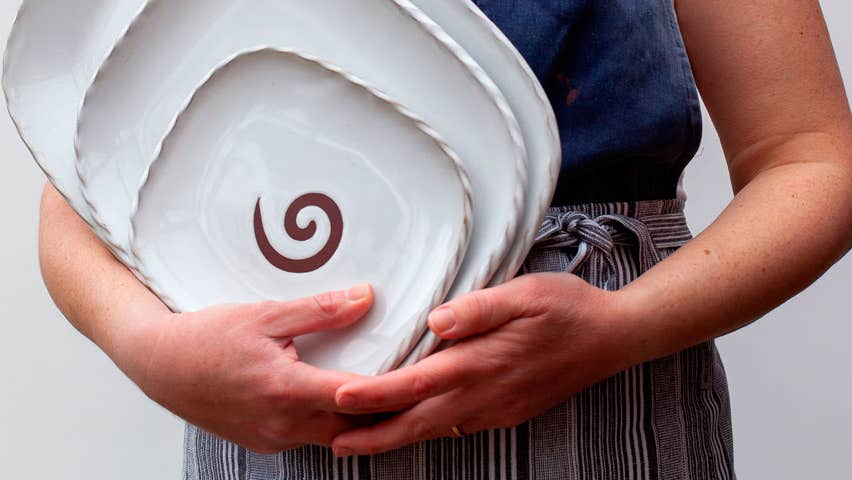 Plates by Shanagarry Potters being held in a woman's arms