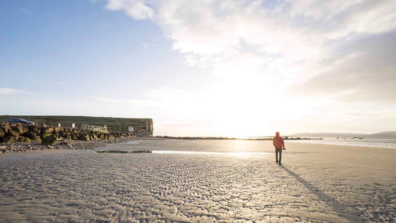 Person walking on the Silver Strand beach in County, Galway