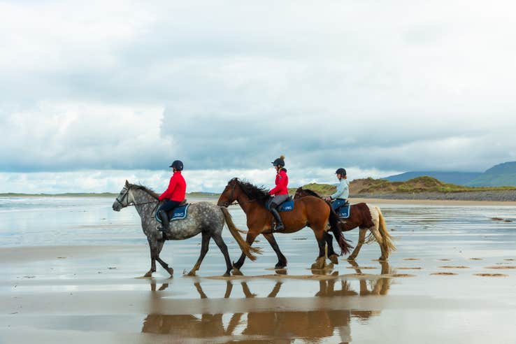 Three women riding horses on the beach in Sligo.