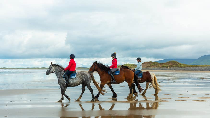 Three women riding horses on the beach in Sligo.