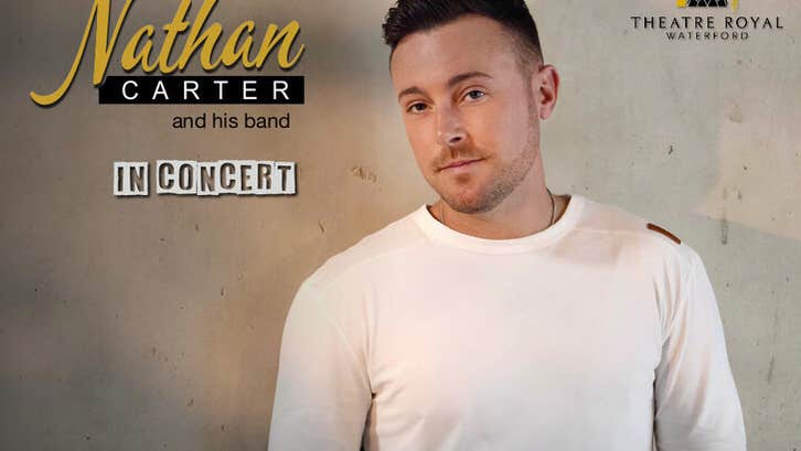 A slightly smiling man in a white top