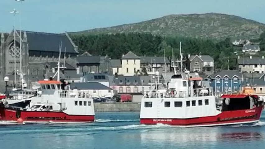 A view of two red and white coloured ferries passing each other in the village harbour