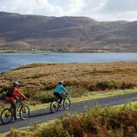 Cyclists by the water on a sunny day