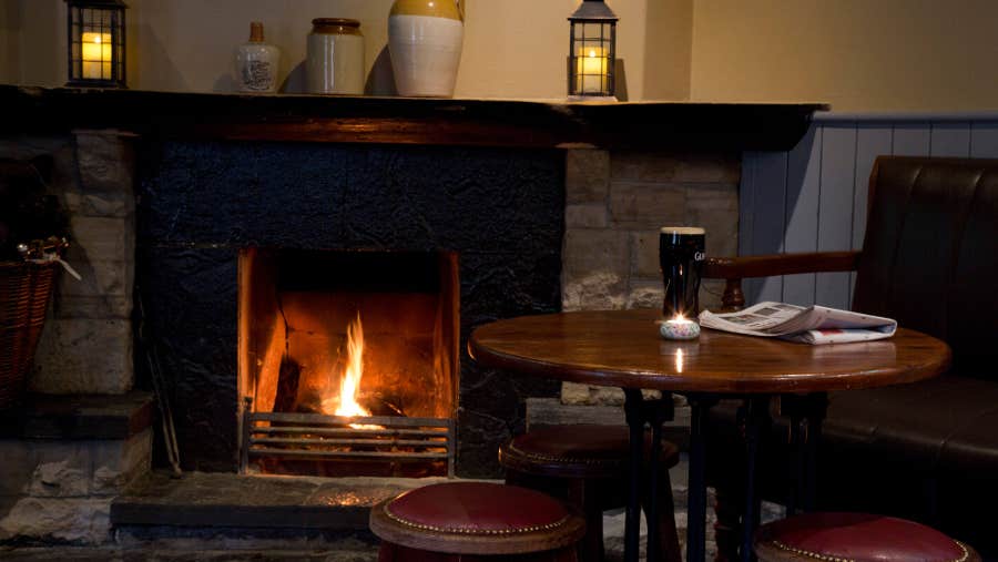 Table and chair next to a fireplace in the bar