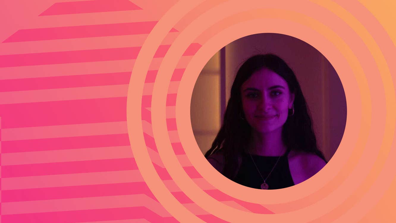 Circular darkly lit photo of woman smiling, surrounded by orange circles with pink stripes to the left.