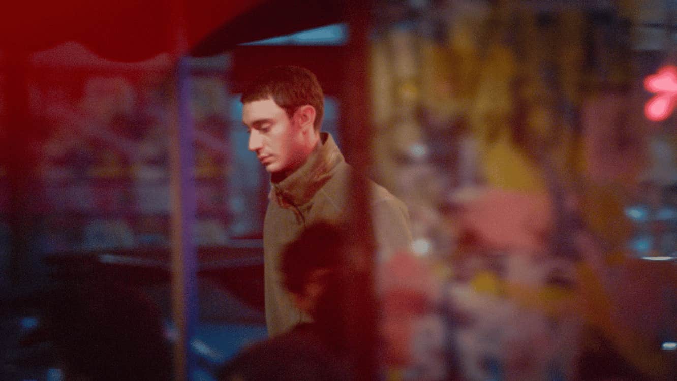 A young man walking along a street.