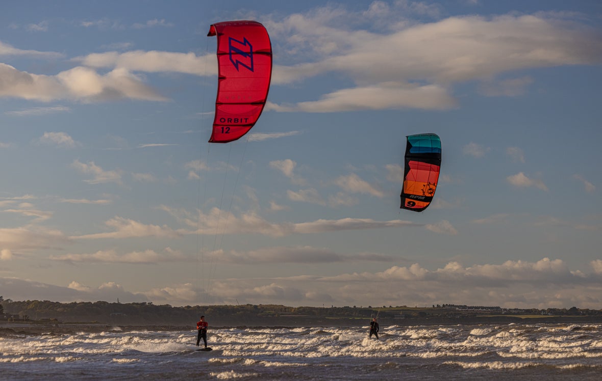 Two kitesurfers out on the water in Dublin.