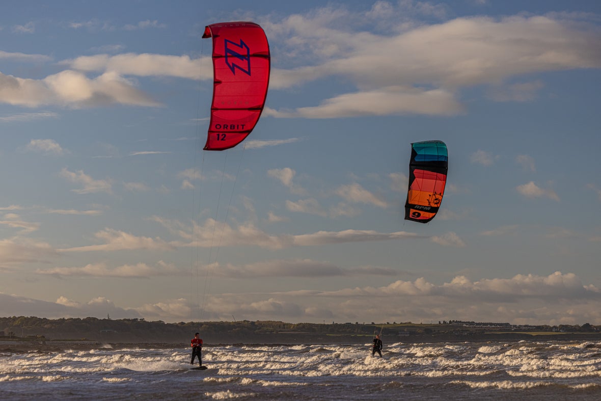 Two kitesurfers out on the water in Dublin.