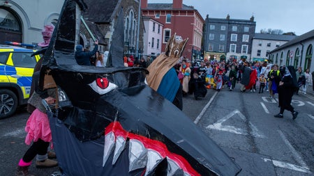 people and puppets in parade