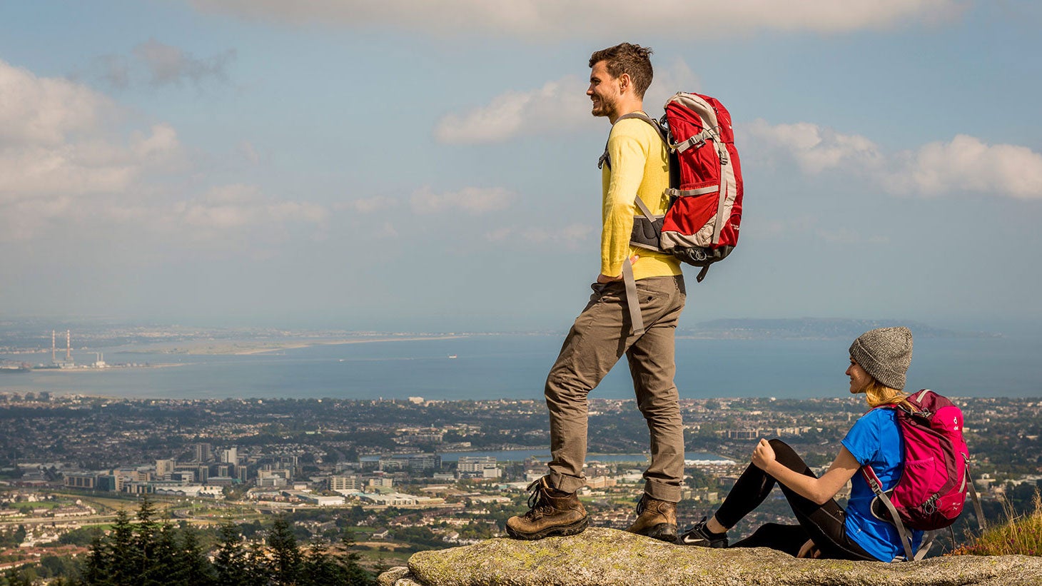 Two people standing on rocks admiring the views from Three Rock Mountain, County Dublin