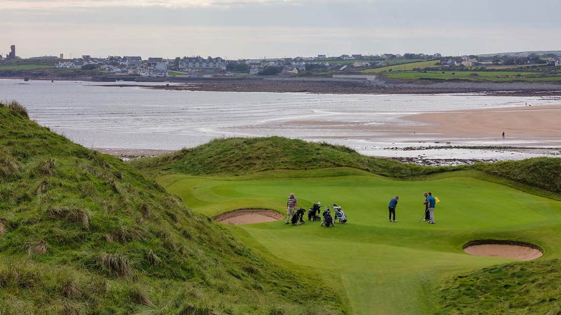 Golfers playing a round by the ocean in Lahinch County Clare