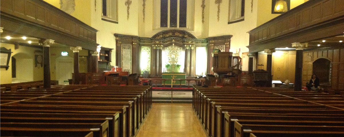 An aisle with pews leading up to an altar