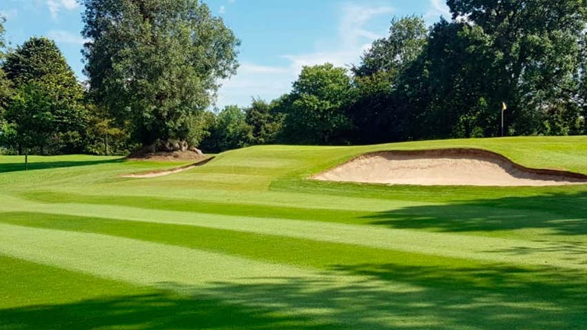 The golf course at Mullingar Golf Club with a sand dune in middle distance and trees in the background