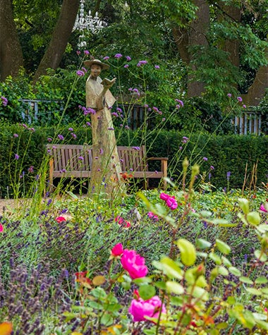 Statue of a figure holding an open book, surrounded by flowers. The Readers Garden at MoLI (Museum of Literature Ireland), Dublin.