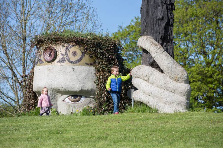 Two kids playing beside a sculpture in Dún na Sí Heritage Park in County Westmeath