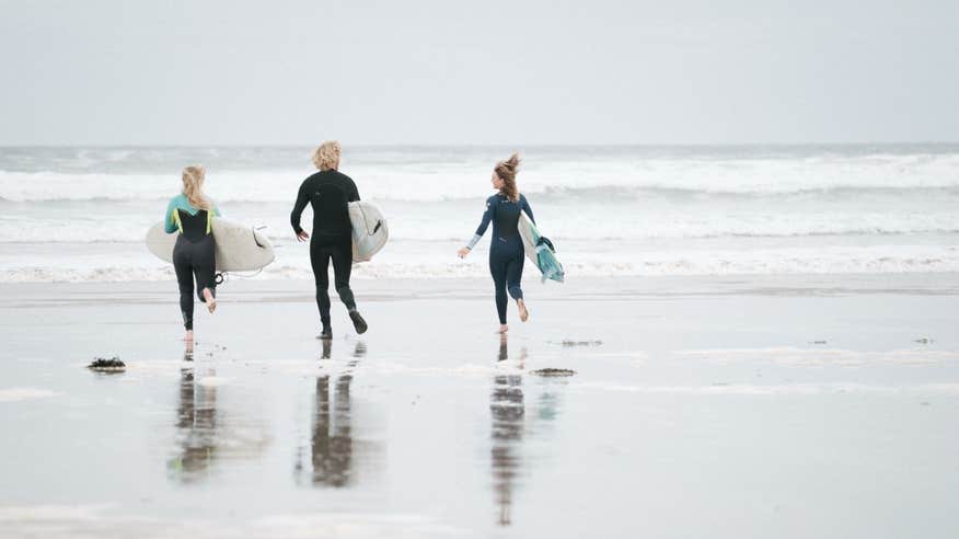 People getting into the sea to go surfing at Lahinch, Co Clare