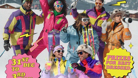 a group of people dressed in brightly coloured ski wear having fun with snowy mountains in background.