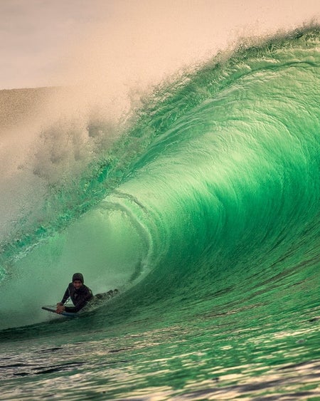 A man surfing a huge wave with Adventure Legend