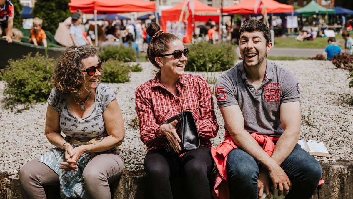 Visitors laughing and enjoying the outdoor market atmosphere.