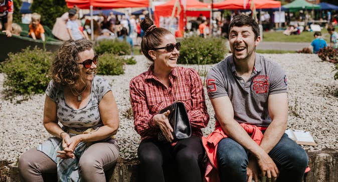 Visitors laughing and enjoying the outdoor market atmosphere.