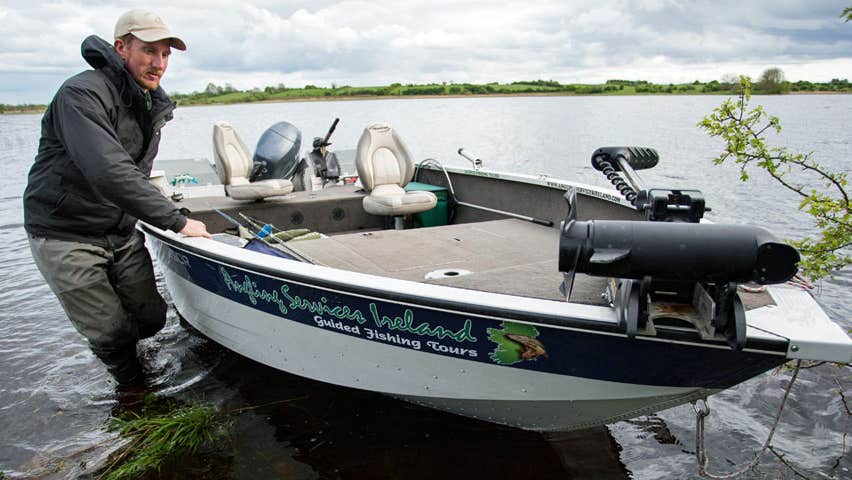 A man in the water bringing his boat ashore