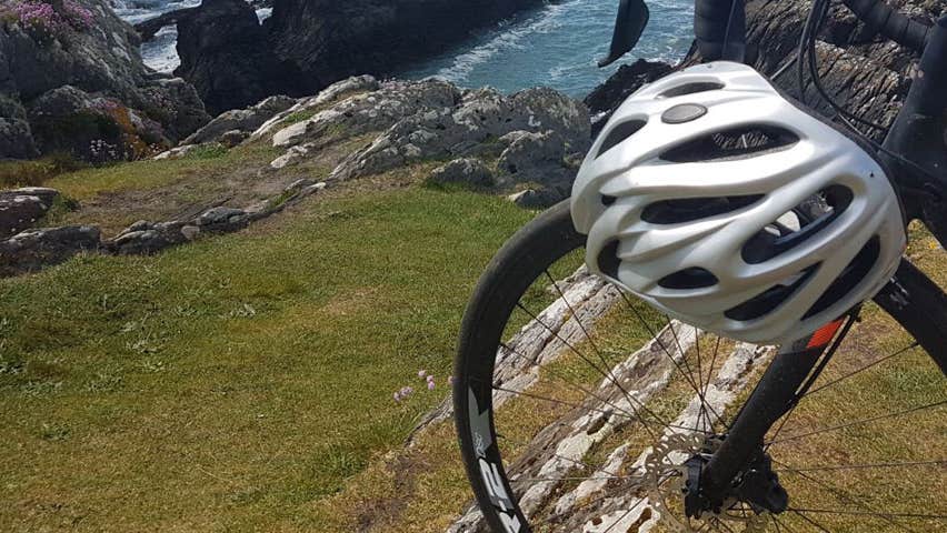 One bicycle sitting beside coastal view