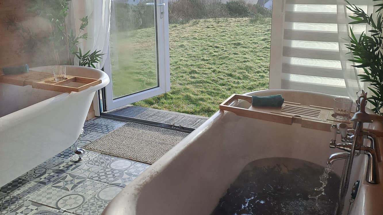 A room with two baths with seaweed and doors open to sea view