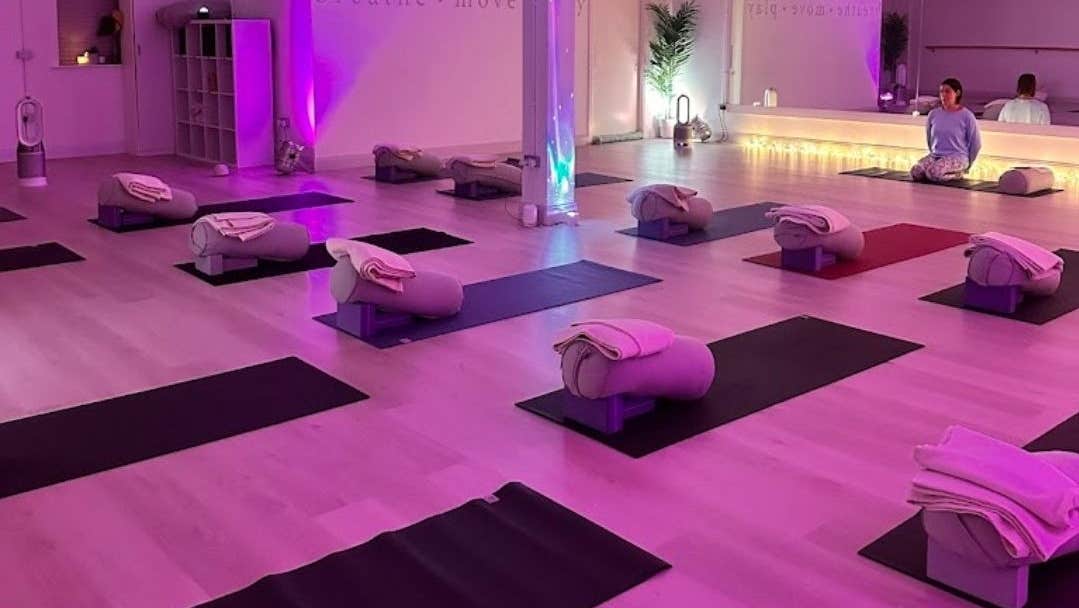 Studio set up for a yoga class with mats and blankets