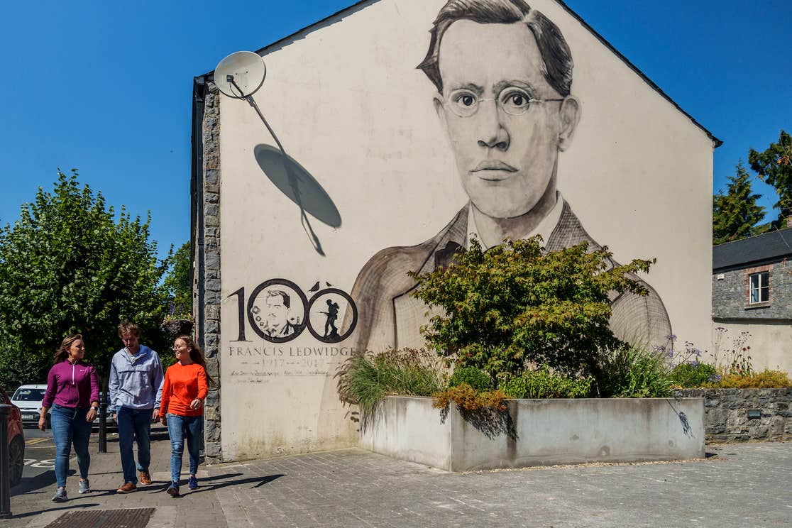 People walking past the Francis Ledwidge mural in Slane, Co Meath