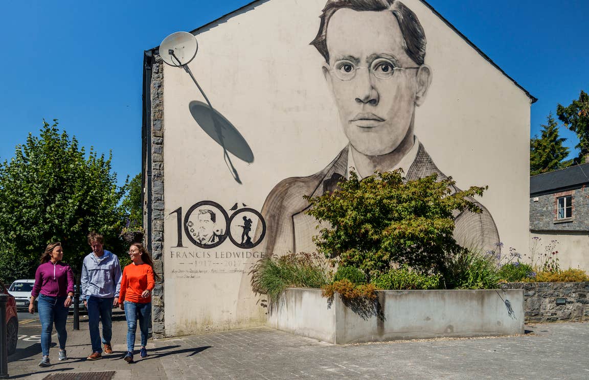 People walking past the Francis Ledwidge mural in Slane, Co Meath